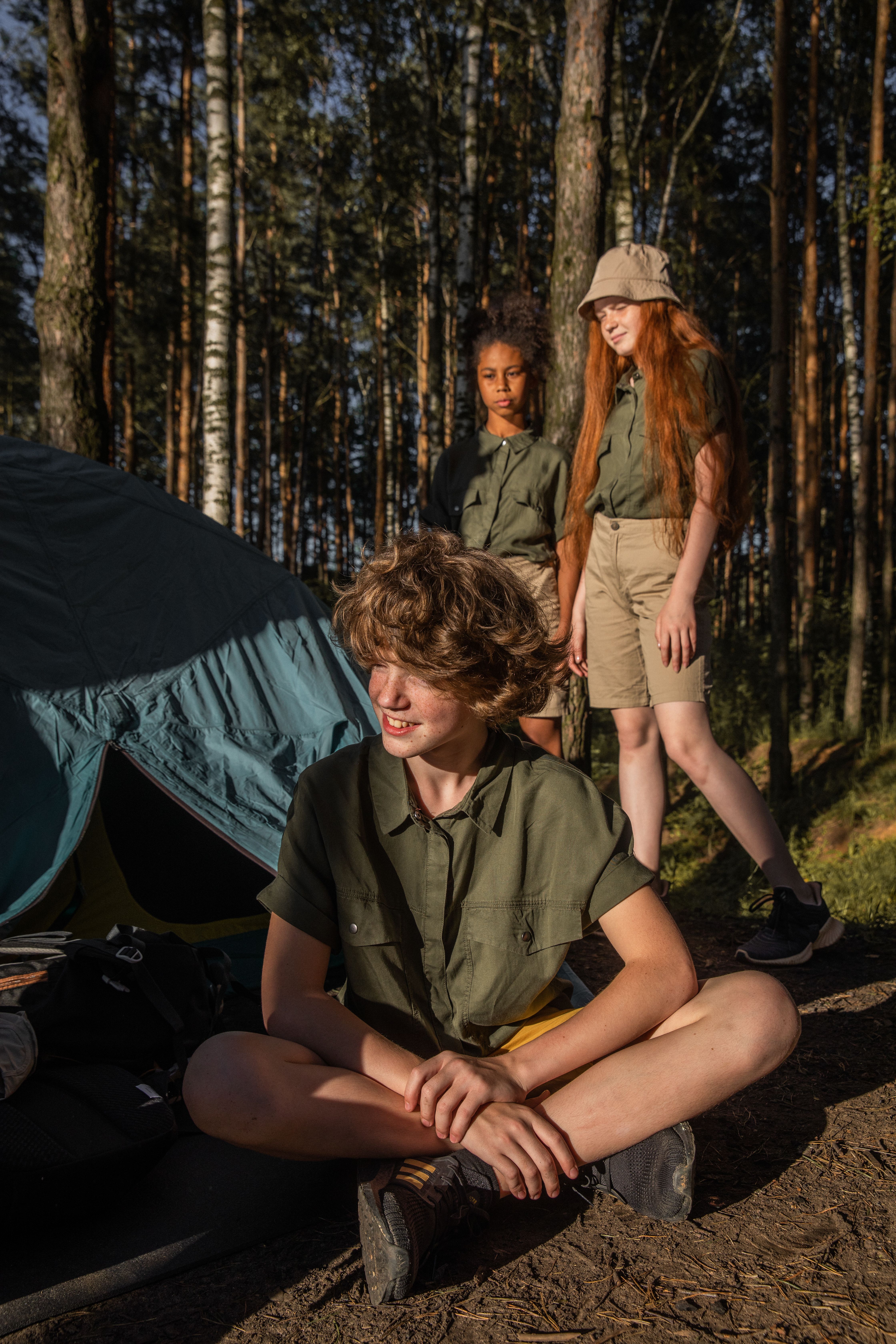 Teenagers camping together in a forest setting