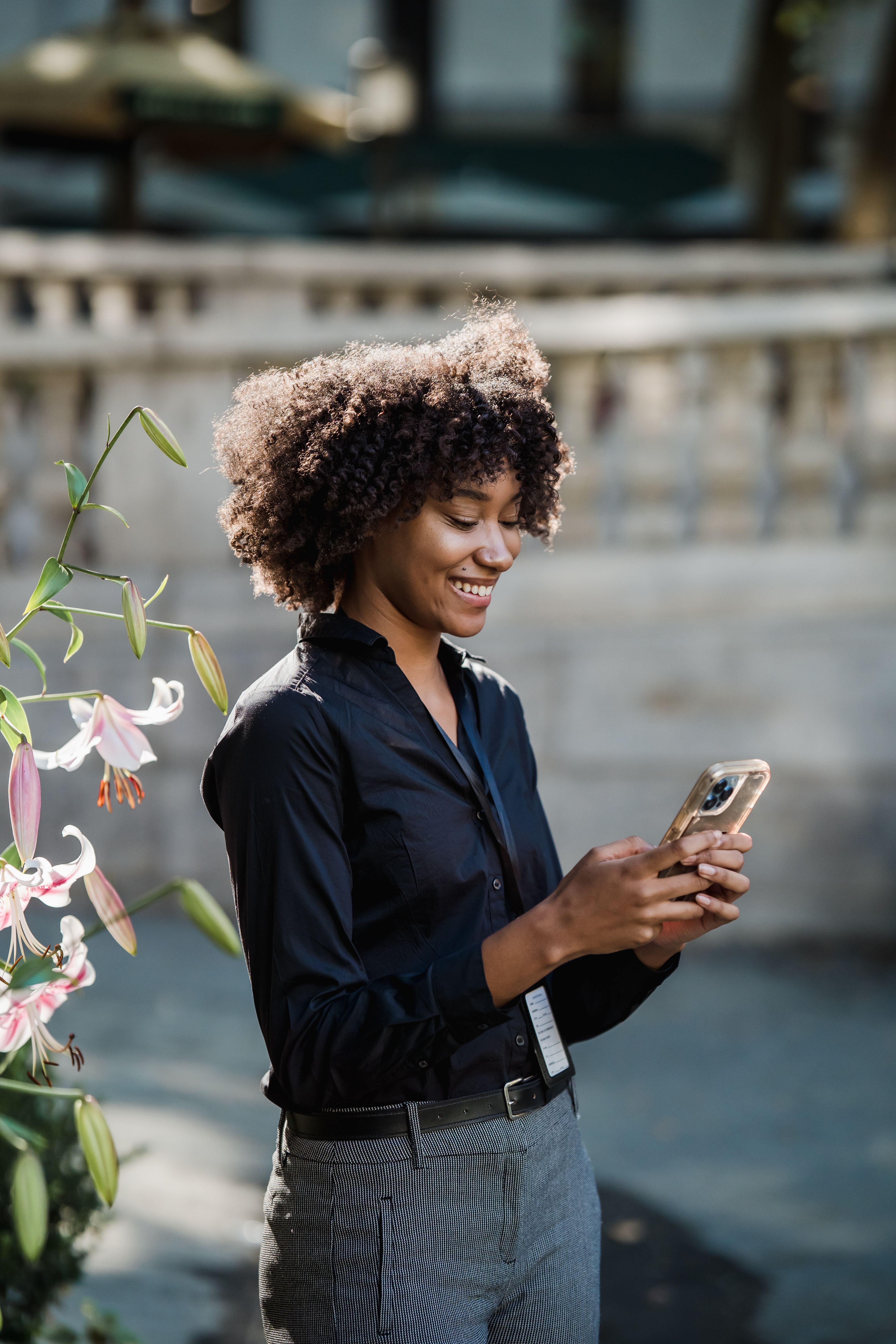 A woman smiling while reading a text message on her phone