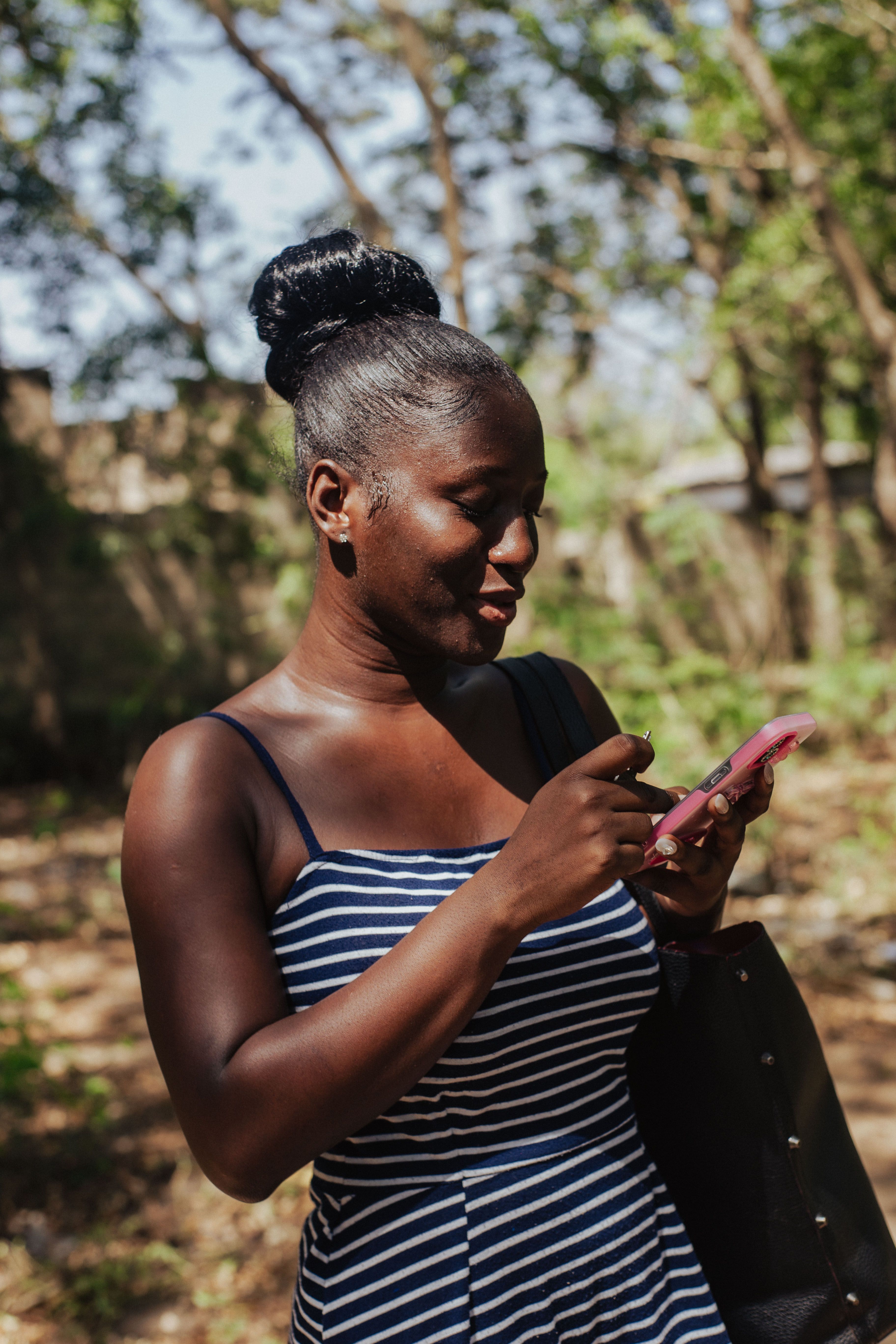 A young woman enjoying her mobile phone outdoors, upbeat